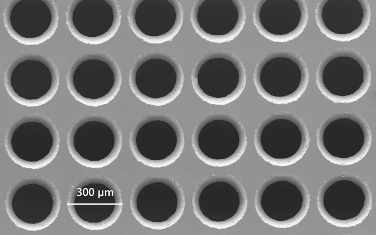 Scanning electron microscope image of drilled 300 µm holes in borosilicate glass.
